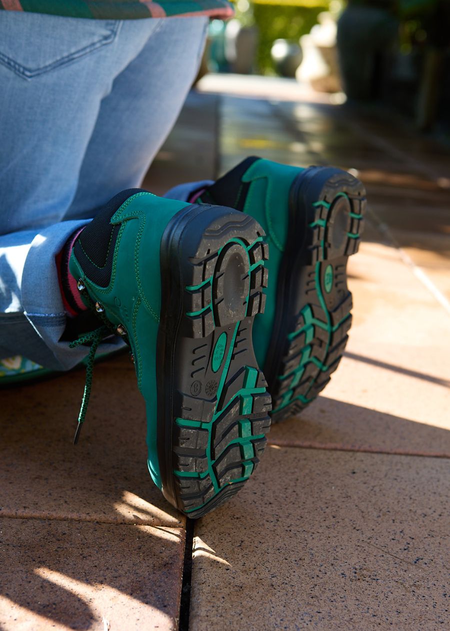 Black slip-resistant sole of Does safety boot featuring green accent colours.