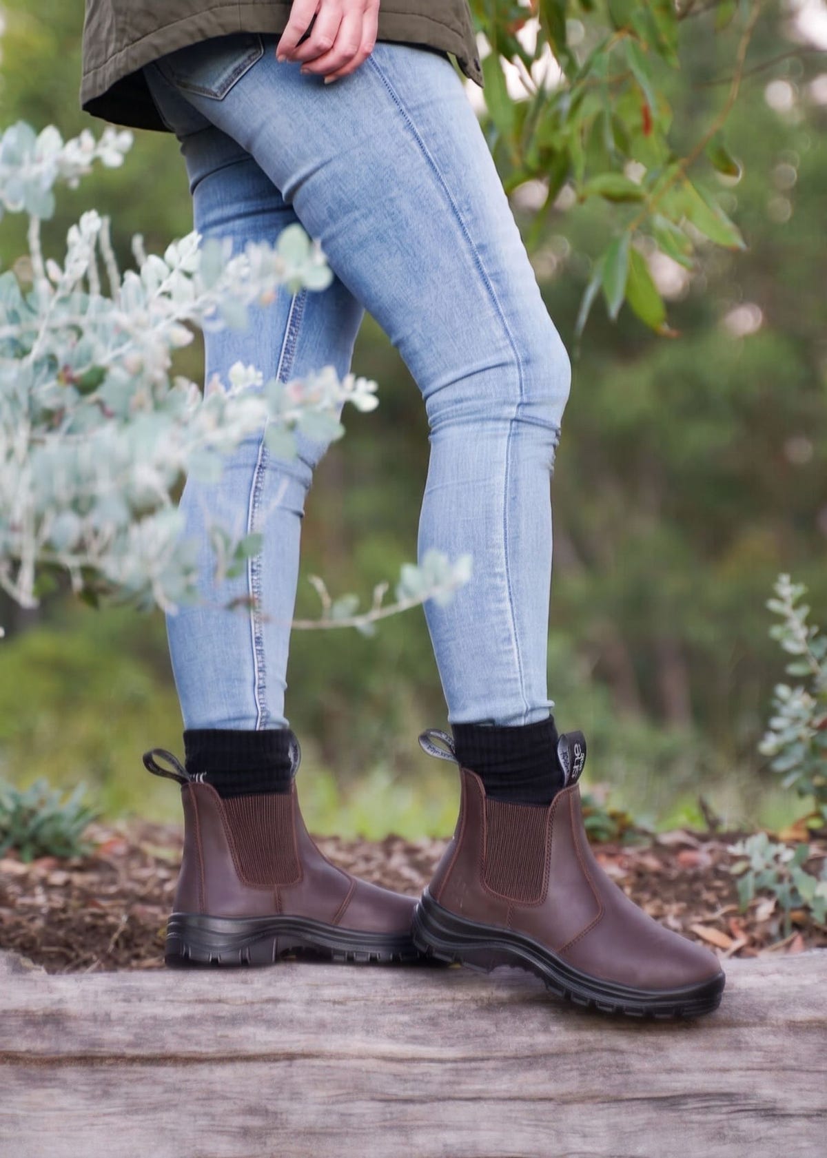 Woman stood on log wearing brown boots