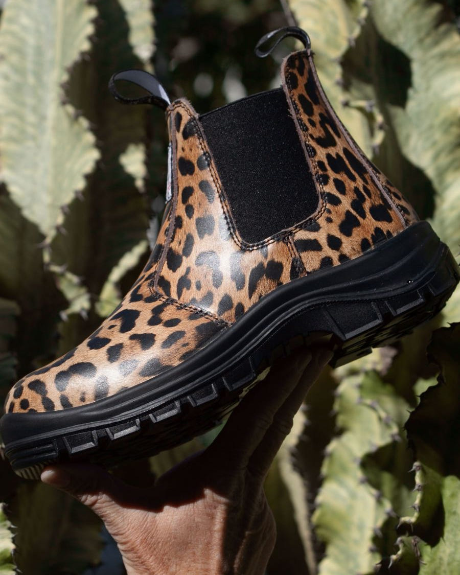 Side profile of a pull-on boot, with black sole and leopard printed leather