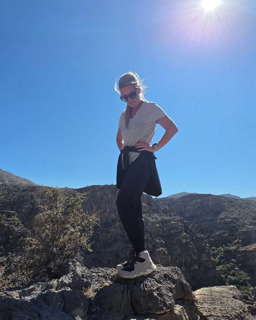 Standing on cliff side in black and grey ankle hiking boots.