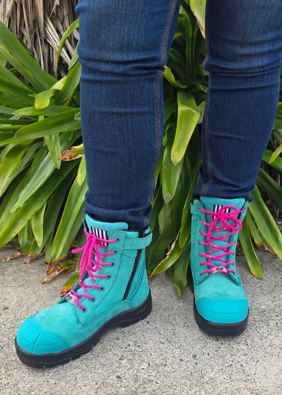 Woman standing in aqua safety boots with pink laces