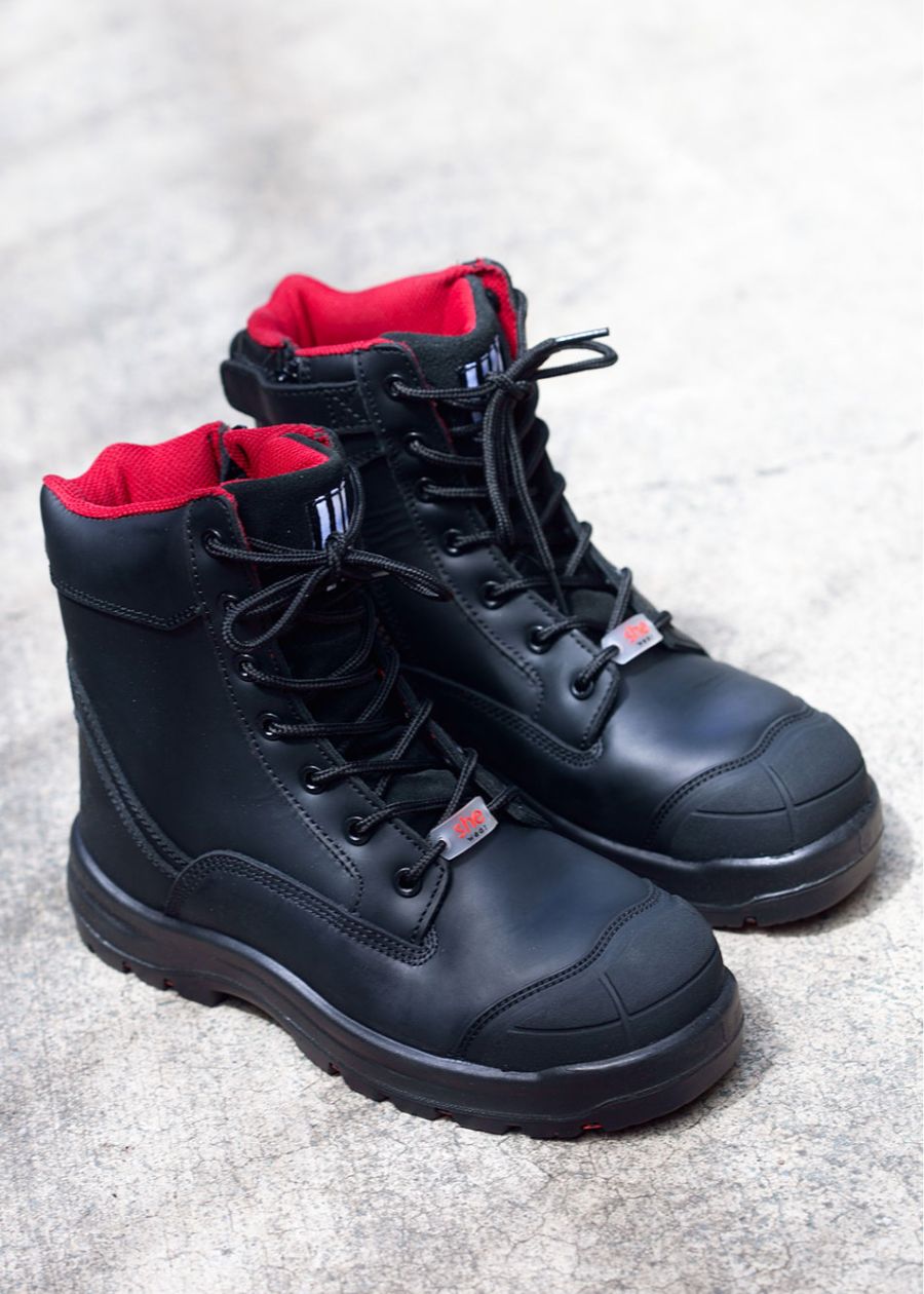 Black lace-up composite boots with red interior lining. 