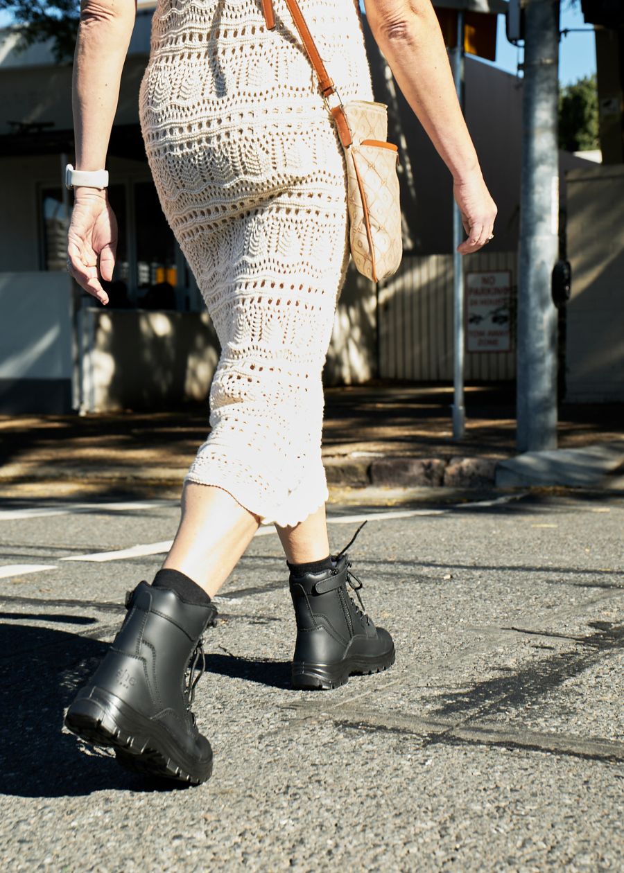Woman walking wearing black work boots