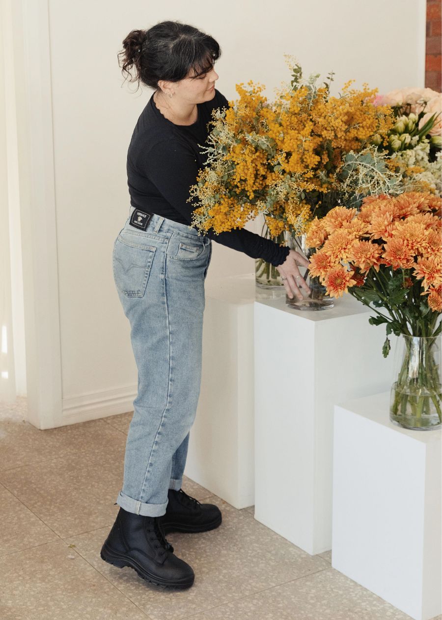 Black work boots with woman in jeans in a florist store