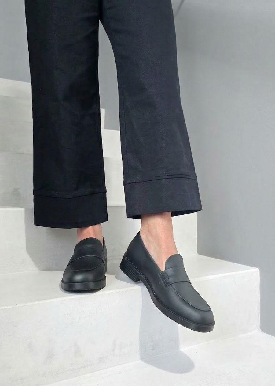 Woman standing on step wearing black work loafer