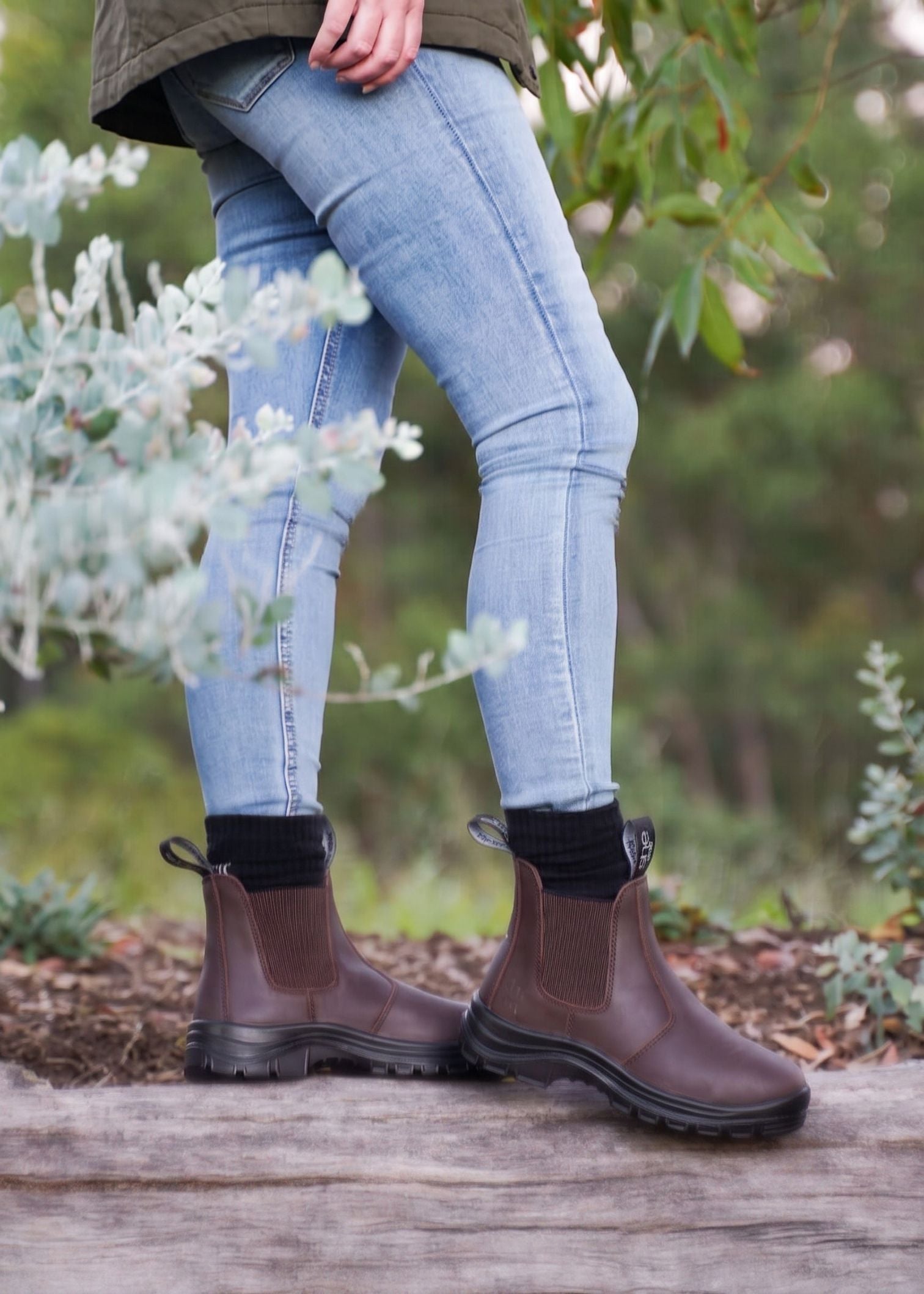 Woman stood on log wearing brown boots