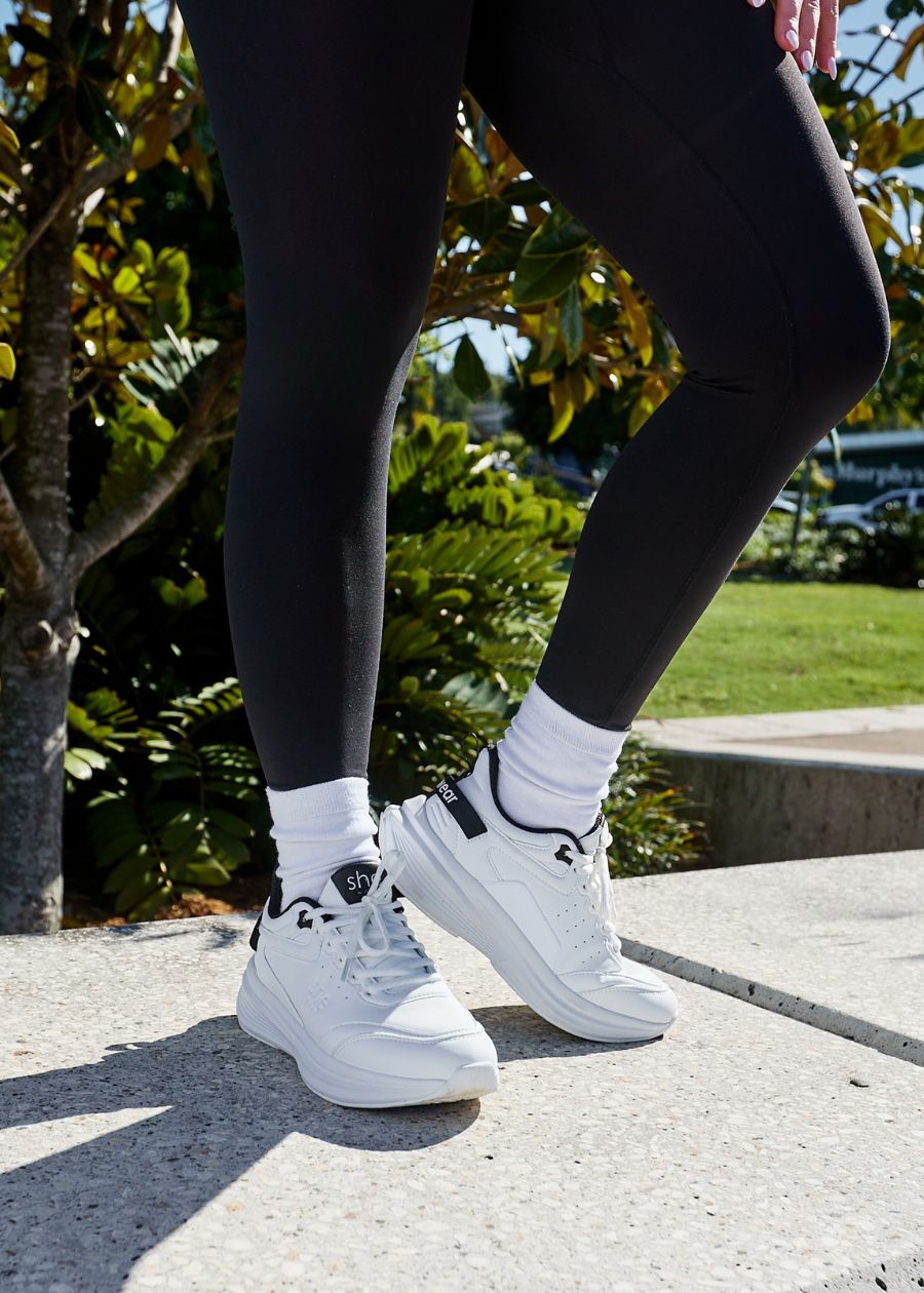 Lady stood up wearing white walking shoe 