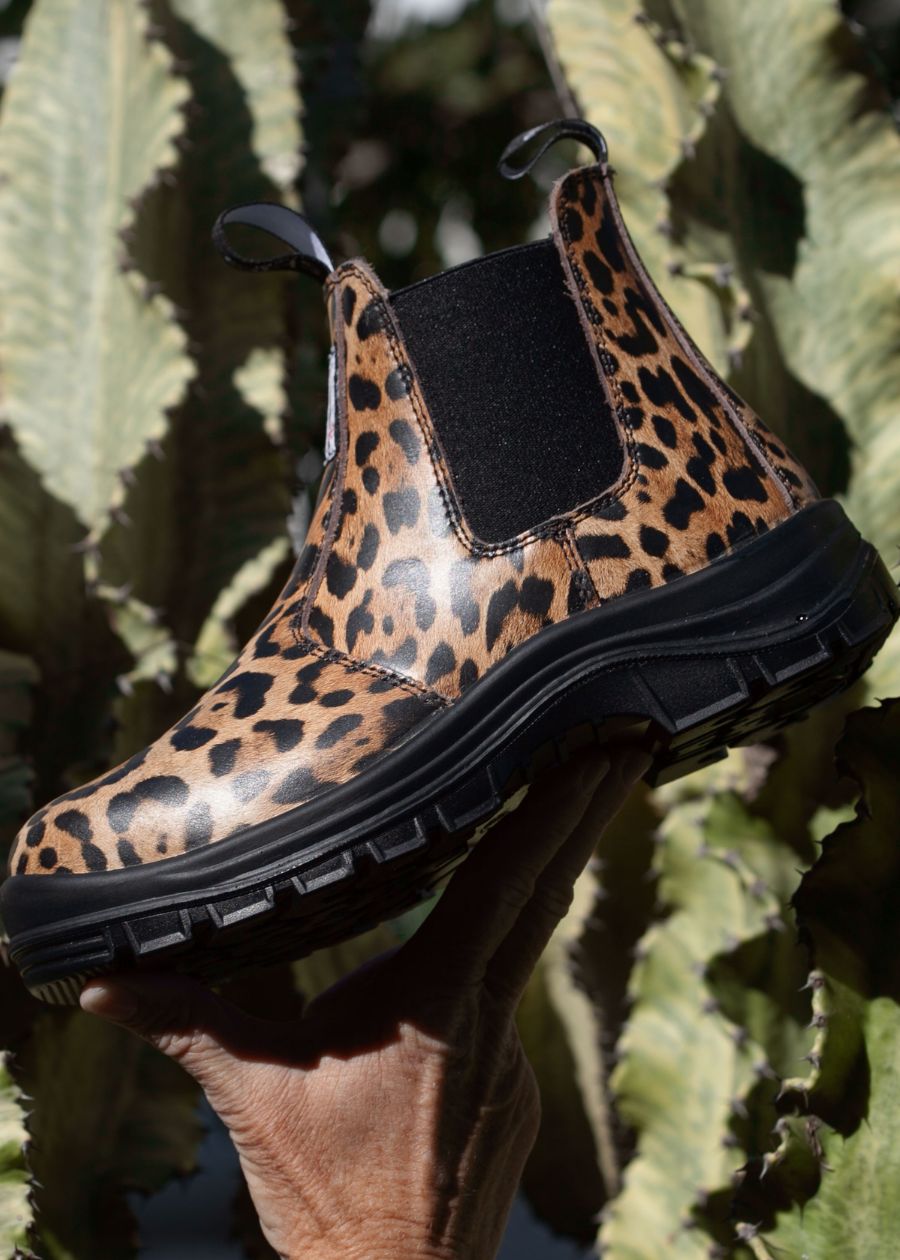 Side profile of a pull-on boot, with black sole and leopard printed leather