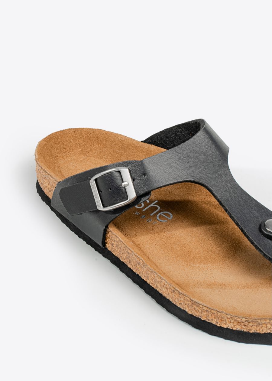 Black adjustable straps and silver buckle on women's cork-style slip-on shoe