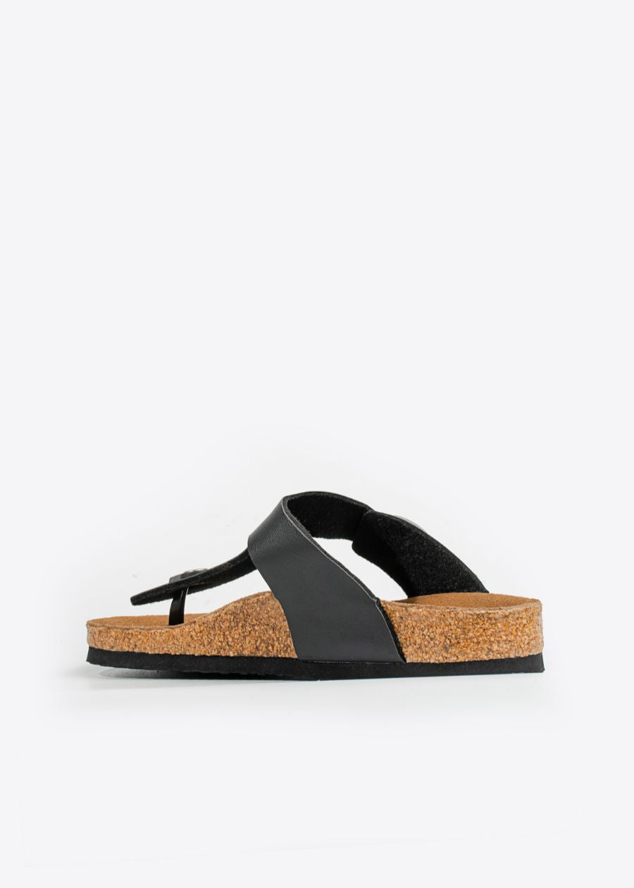 side view of wander thong style slide with black straps, and brown cork sole. 
